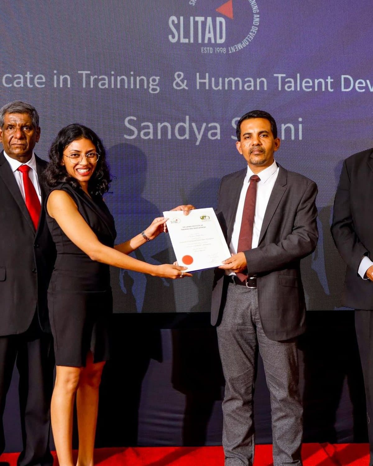 A graduate receives her Certificate in Training & Human Talent Development under the SLITAD seal